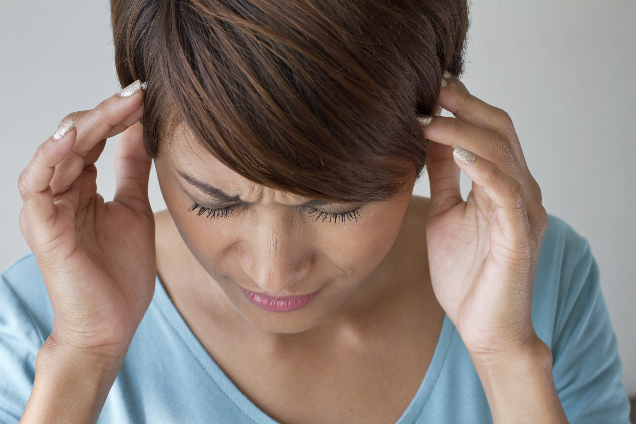 Soforthilfe bei Erschöpfung woman suffers from pain, headache, sickness, migraine, stress, insomnia, hangover in casual dress, two hands holding head